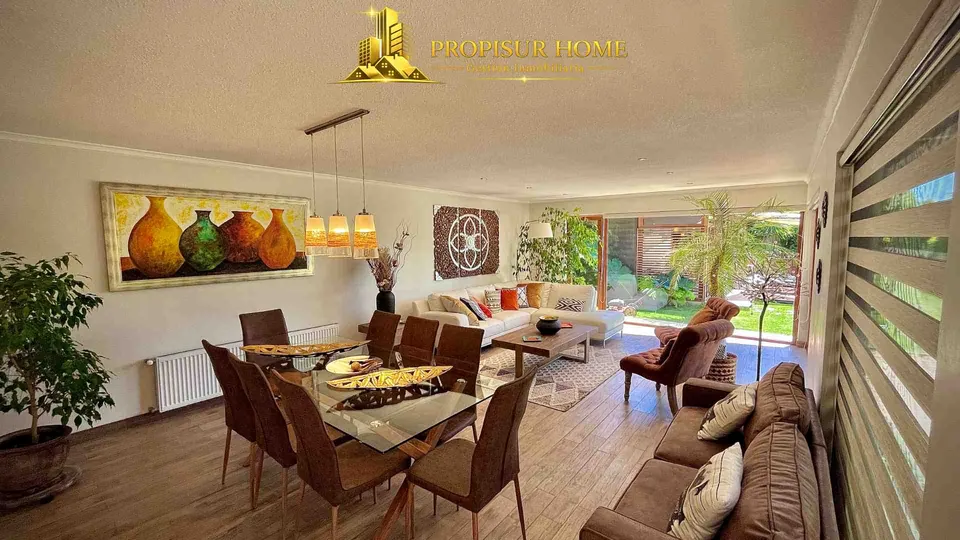 Comedor y living con vista al jardín y piscina en casa exclusiva en venta en Angol