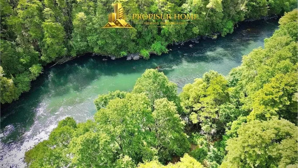 Vista aérea del río Trancura rodeado de bosque nativo en el complejo turístico en venta en Pucón - Propisur Home SpA.
