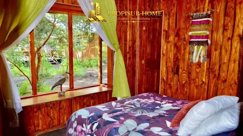 Dormitorio principal de una cabaña completamente equipada del complejo turístico en venta en Pucón - Propisur Home SpA.
